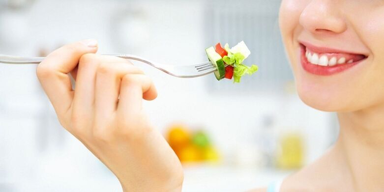A lány zöldségsalátát eszik, és kedvenc diétájával fogy